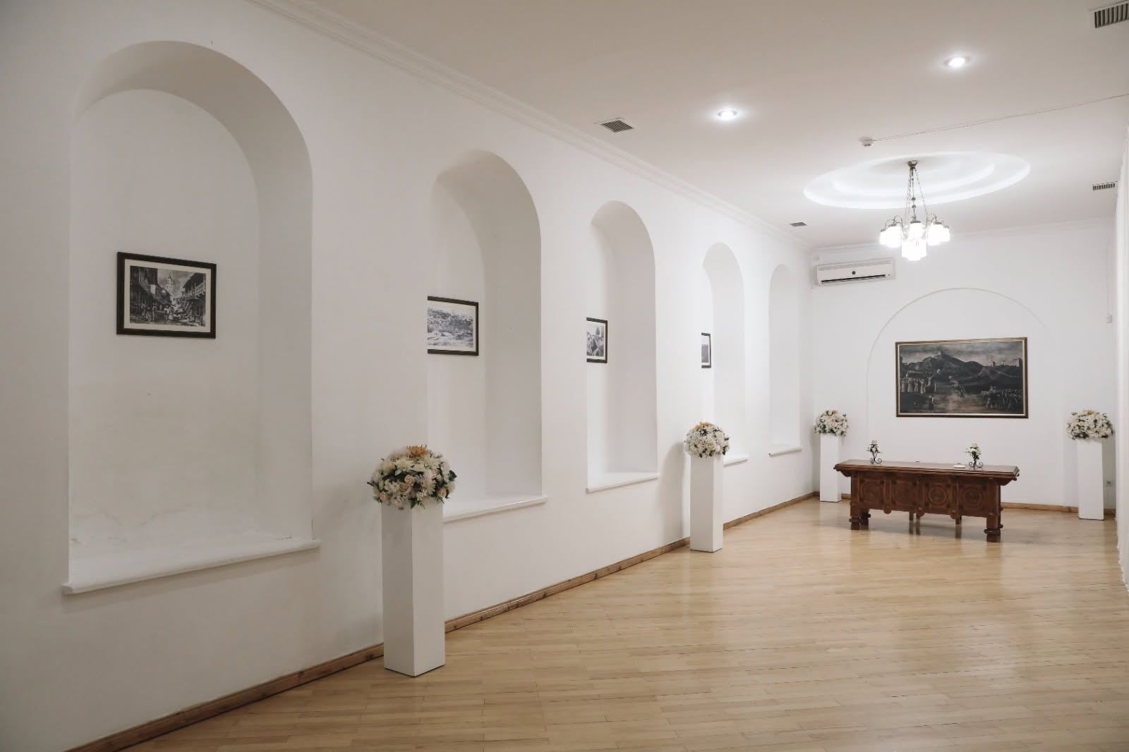 White gallery hall with arched alcoves
